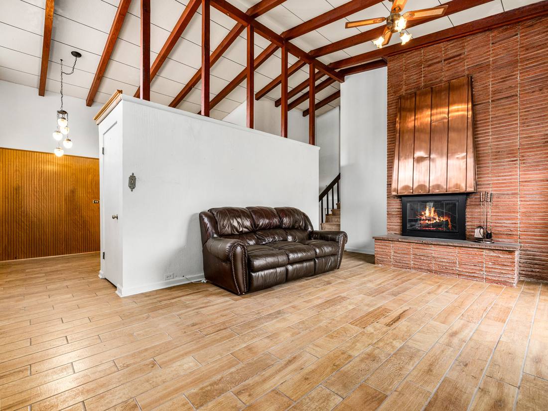 Kitchen with oak cabinetry, brick and exposed beams