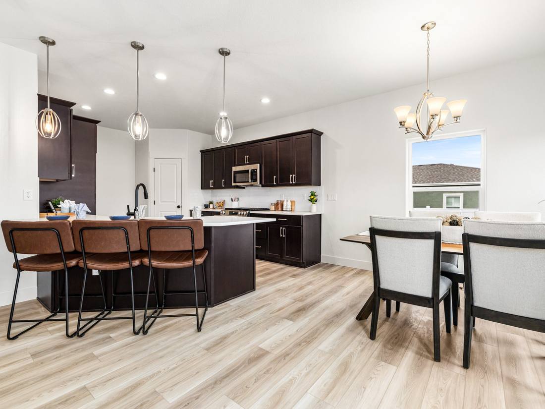 Kitchen with dark cabinetry, island seating and a dining area