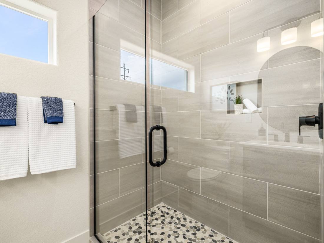 Tiled walk-in shower with a pebble floor