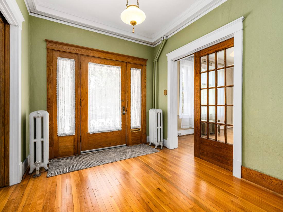 Entry hall with an oak door, sidelights and cast iron radiators