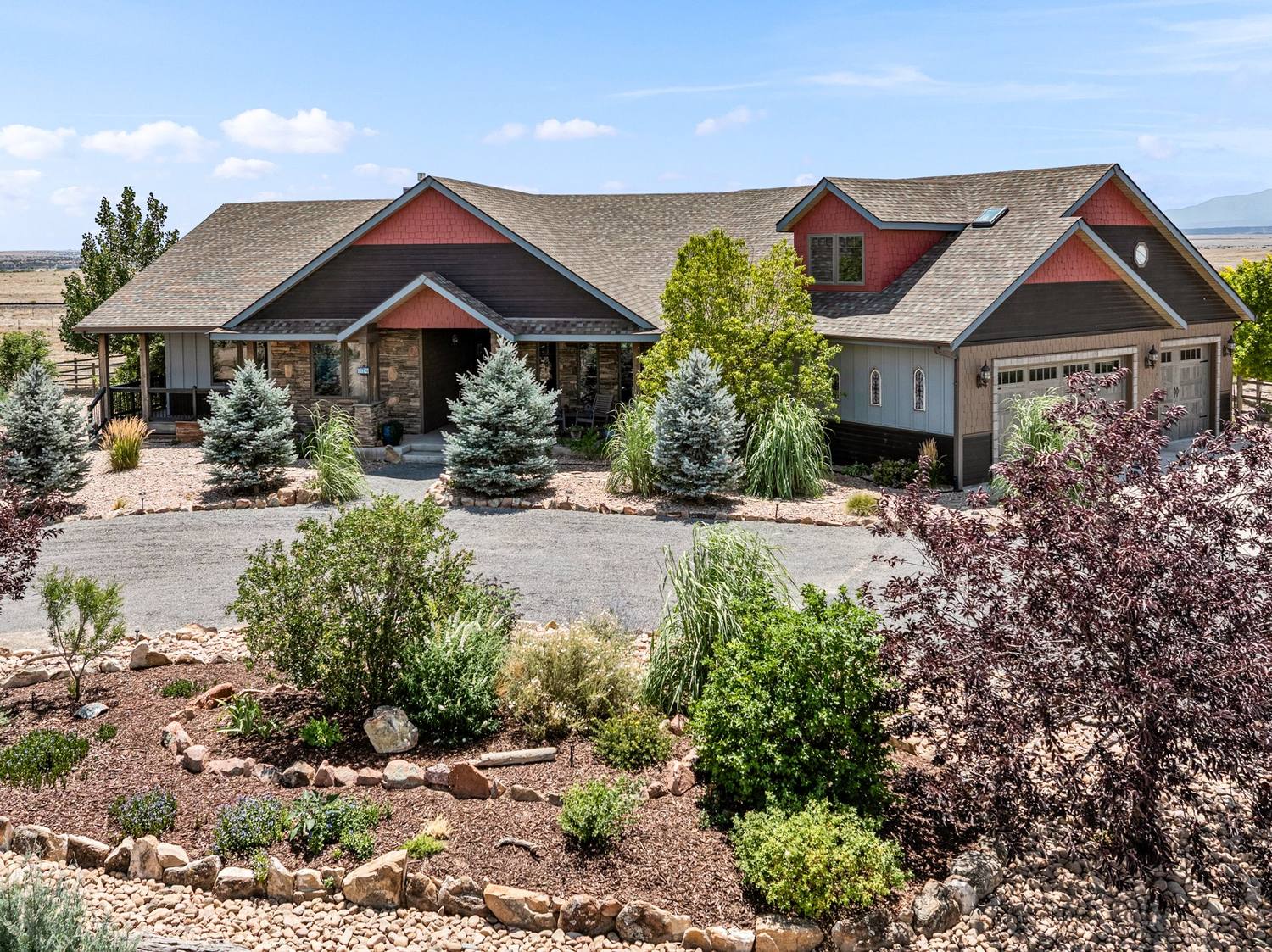 Exterior of a Pueblo West home with landscaped rock garden and mountains behind