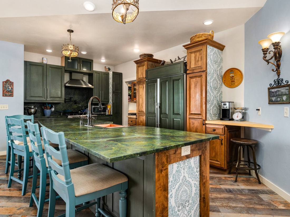 Kitchen with a green marble island and copper farmhouse sink